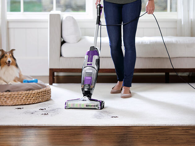 Woman Vacuuming carpet with Bissell Crosswave Vacuum at Stark's Vacuums
