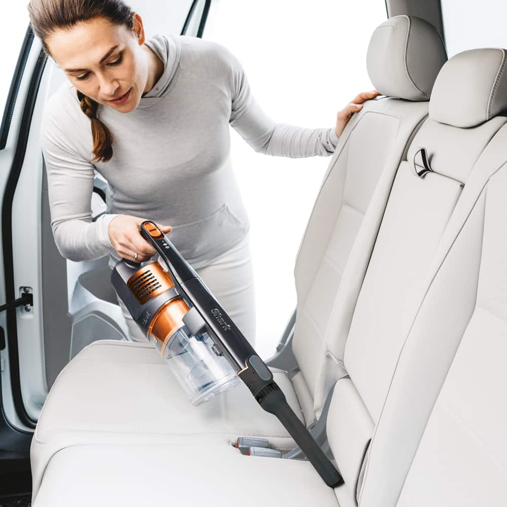 Woman cleaning car with Shark Vacuum