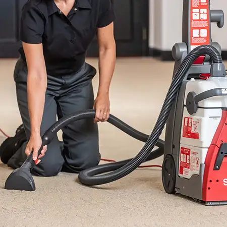 Woman cleaning the carpet with a Sanitaire vacuum cleaner rental from Stark's Vacuums