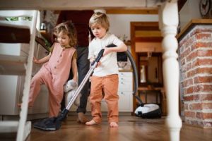 Father with two small children vacuuming their home - Learn about Kid-Friendly Holiday Cleaning Activities: Making Chores Fun with Stark's Vacuums